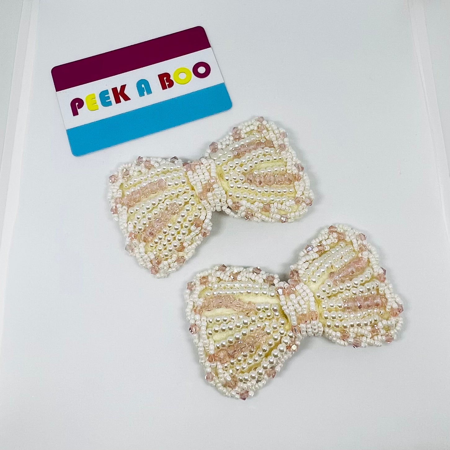 Lazo de canutillos rosados y perlas PEEK A BOO