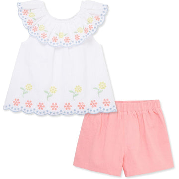 White top with floral embroidery and pink shorts on a white background